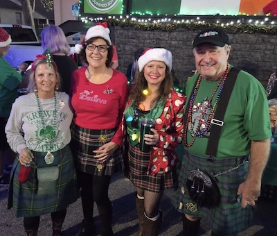 Members in kilts and holiday attire at a Christmas parade