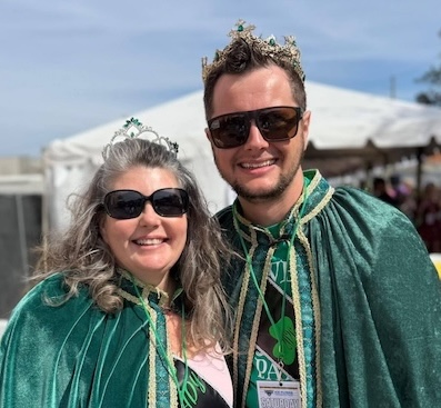 Krewe royalty in green capes at a parade